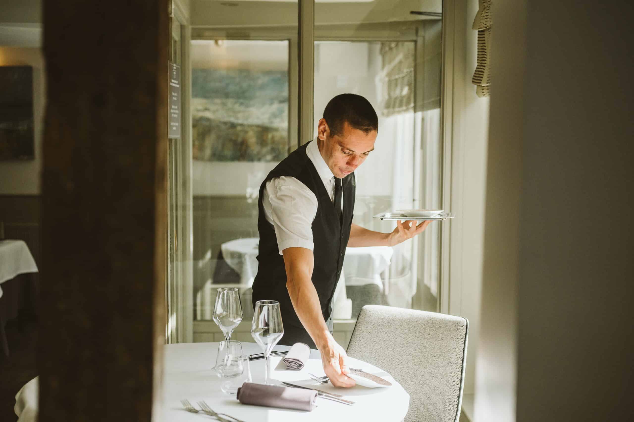 Waiter Sets a table in the restaurant